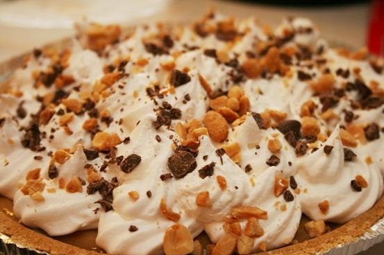 Caramel pie garnished with chopped nuts and chocolate chips